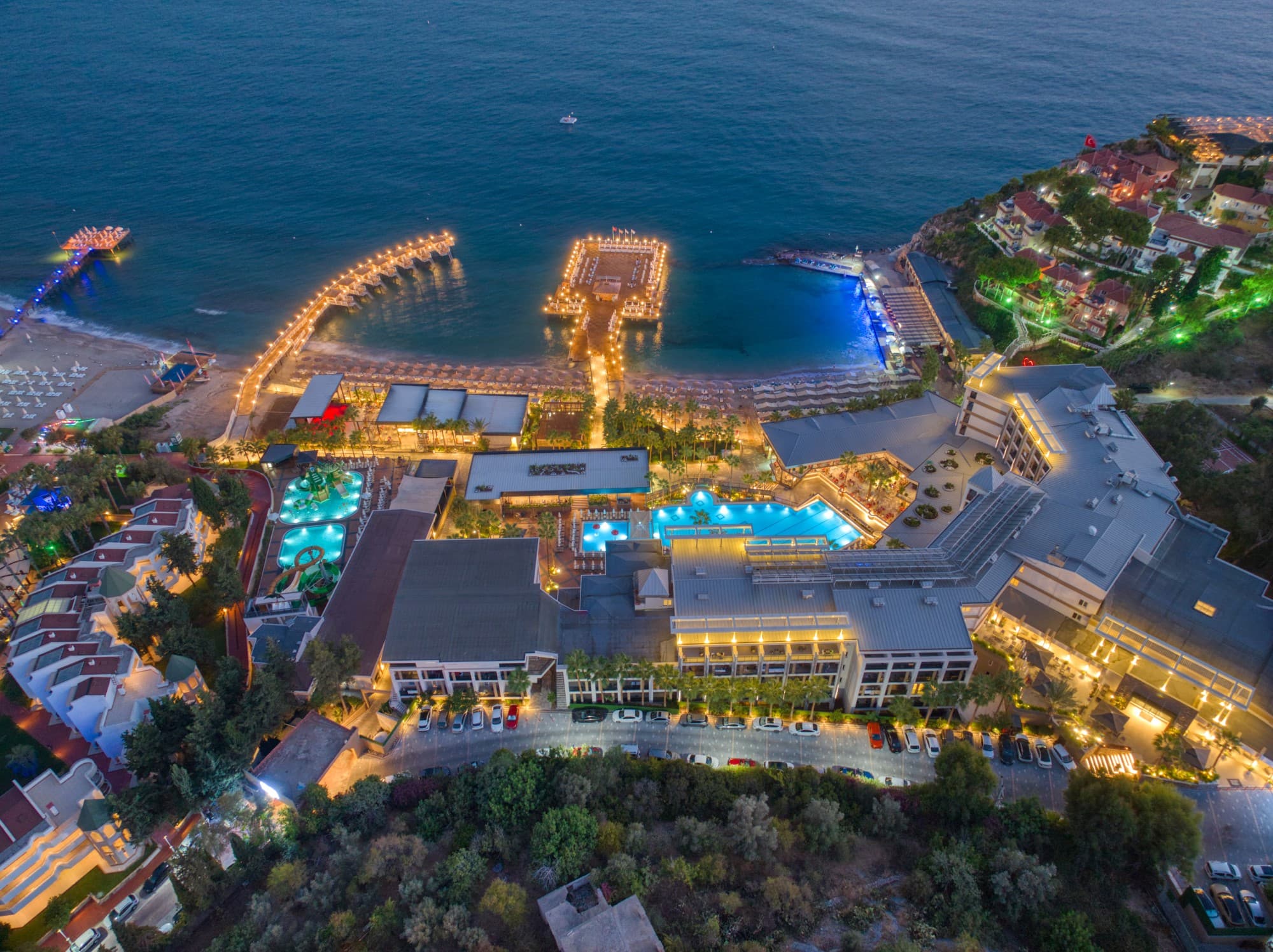 Gece ışıklandırılmış otel ve iskelelerin havadan görünümü